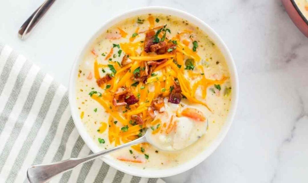 Cheesy chicken chowder recipe in a Dutch oven topped with melted cheddar and fresh parsley