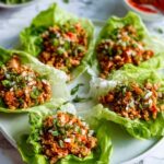Chicken lettuce wraps with seasoned ground chicken filling, rice, and toppings served in butter lettuce cups