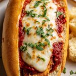 Crispy chicken parm sandwich with melted mozzarella and marinara sauce on a toasted hoagie roll