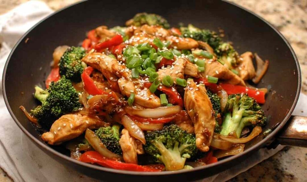 Chicken teriyaki stir fry with juicy chicken, broccoli, carrots, and bell peppers in a glossy teriyaki sauce served over white rice