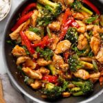 Chicken teriyaki stir fry with juicy chicken, broccoli, carrots, and bell peppers in a glossy teriyaki sauce served over white rice
