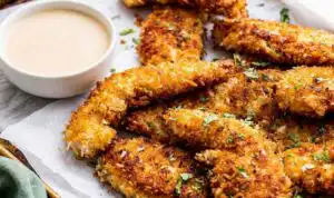 Crispy coconut chicken tenders on a plate served with pina colada dipping sauce