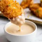 Crispy coconut chicken tenders on a plate served with pina colada dipping sauce