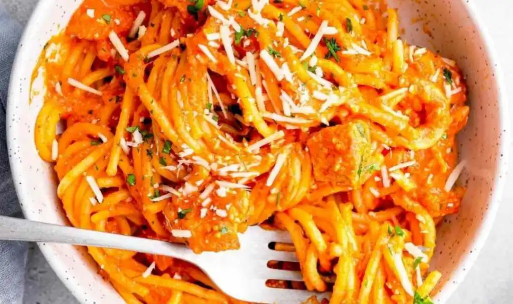 Crockpot chicken spaghetti in a slow cooker with creamy marinara sauce and melted mozzarella cheese
