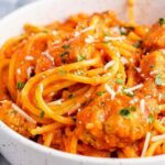 Crockpot chicken spaghetti in a slow cooker with creamy marinara sauce and melted mozzarella cheese