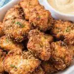 Homemade fried chicken nuggets golden and crispy on a plate with honey mustard dipping sauce