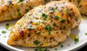 Juicy sliced Instant Pot chicken breast on a white plate garnished with fresh parsley