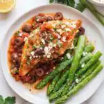 Mediterranean chicken skillet with kalamata olives, feta, and fresh parsley in a large pan