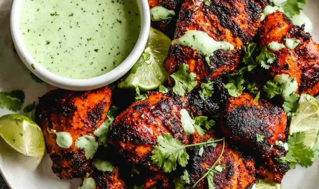Peruvian Chicken with Green Sauce 5 Juicy Peruvian chicken thighs drizzled with creamy cilantro green sauce on a serving platter