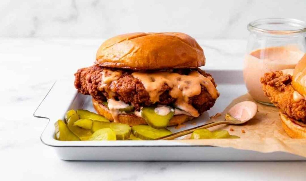 Crispy Popeyes chicken sandwich copycat on a toasted brioche bun with dill pickles and spicy honey mayo