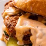 Crispy Popeyes chicken sandwich copycat on a toasted brioche bun with dill pickles and spicy honey mayo