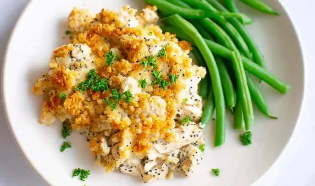 Poppy seed chicken casserole baked in a white 9x13 dish with golden buttery cracker topping fresh from the oven