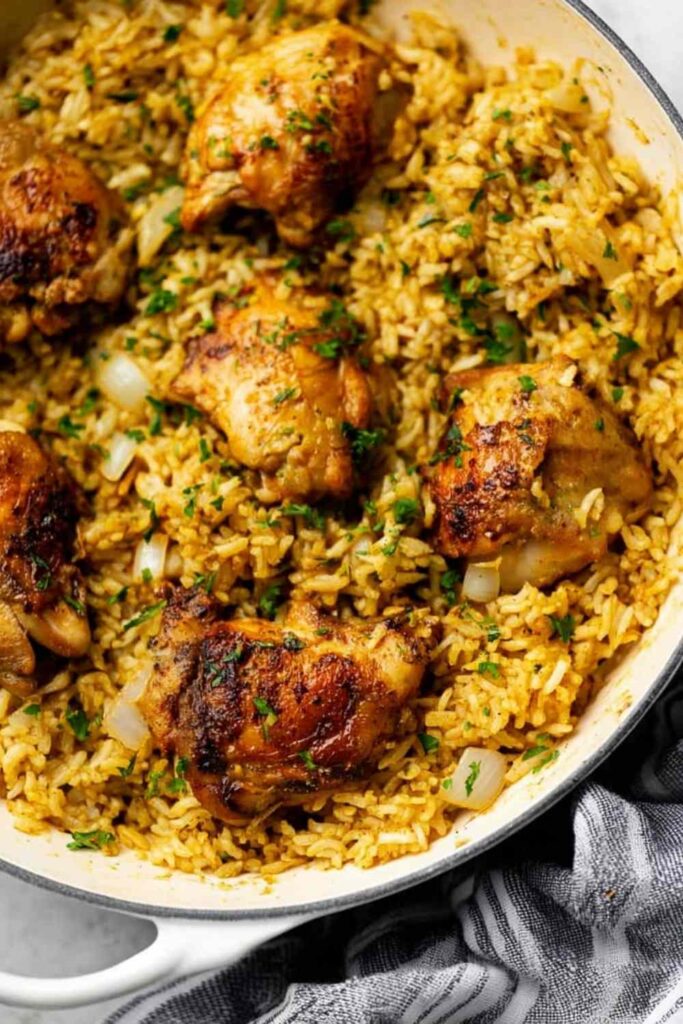 Creamy ranch chicken and rice recipe in a large saute pan topped with fresh parsley
