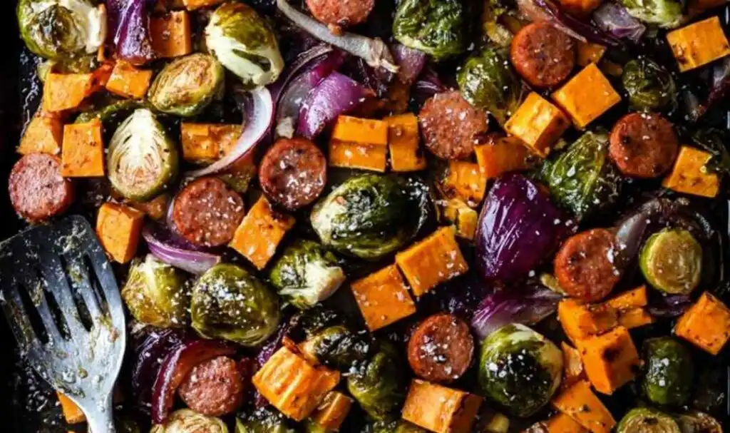 Sheet pan chicken sausage and veggies with crispy Brussels sprouts and caramelized sweet potatoes on a large baking sheet