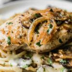 Stuffed chicken Marsala with fontina cheese in Marsala mushroom cream sauce in a skillet