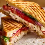 Toasted Frontega Chicken Panini sliced in half showing melted mozzarella and chipotle mayo on golden focaccia